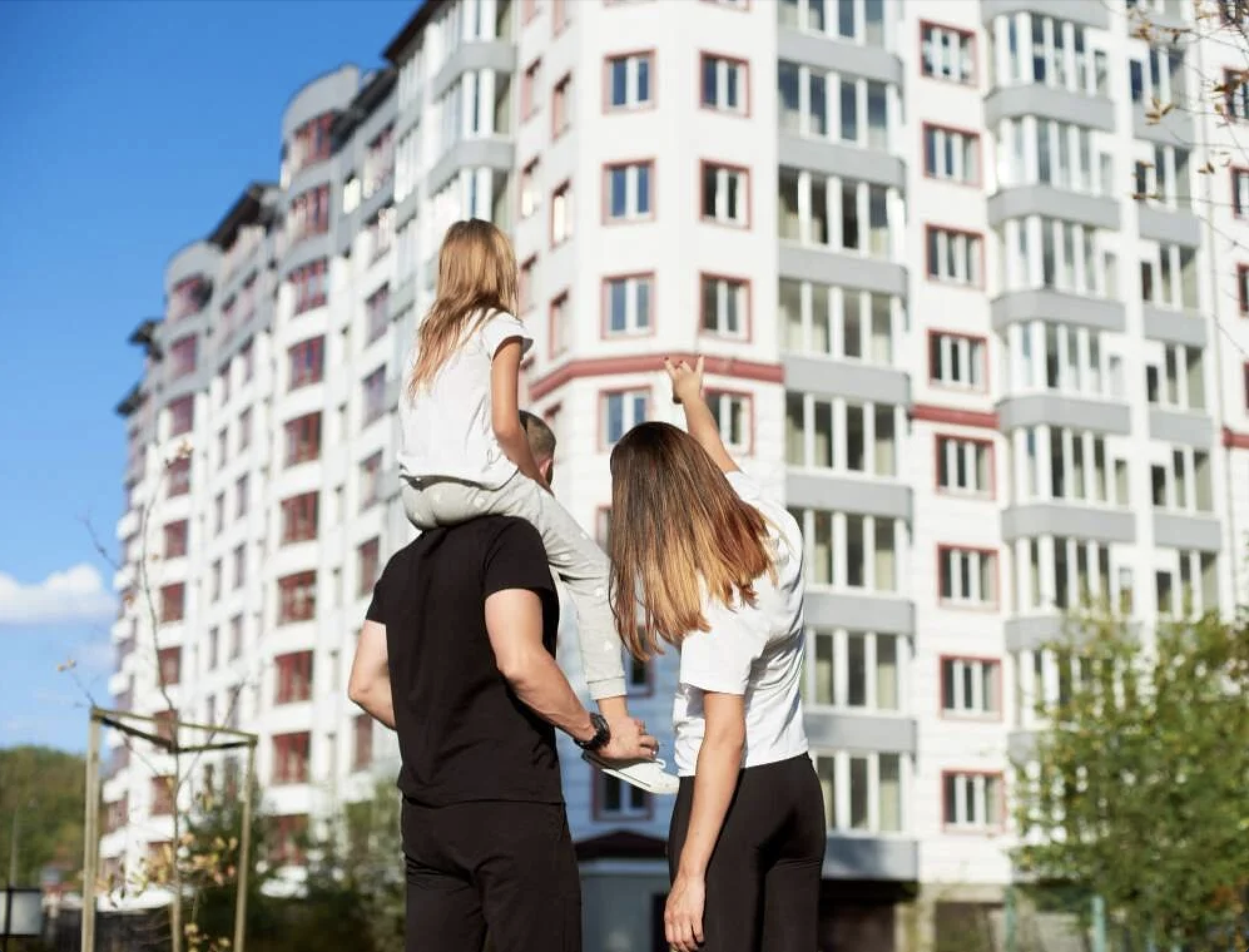 Bilde av en familie foran sitt nye hjem 